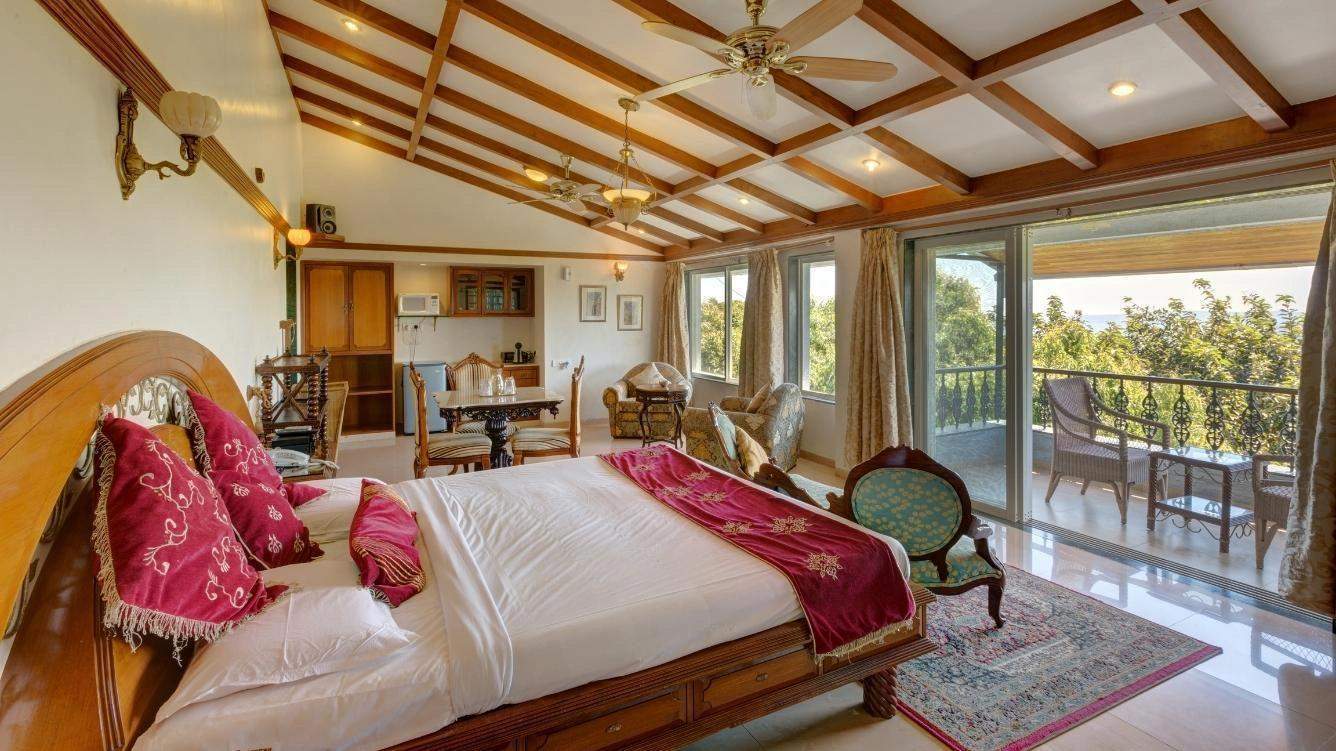 Luxurious suite with traditional decor and large windows at Ramsukh Resort.